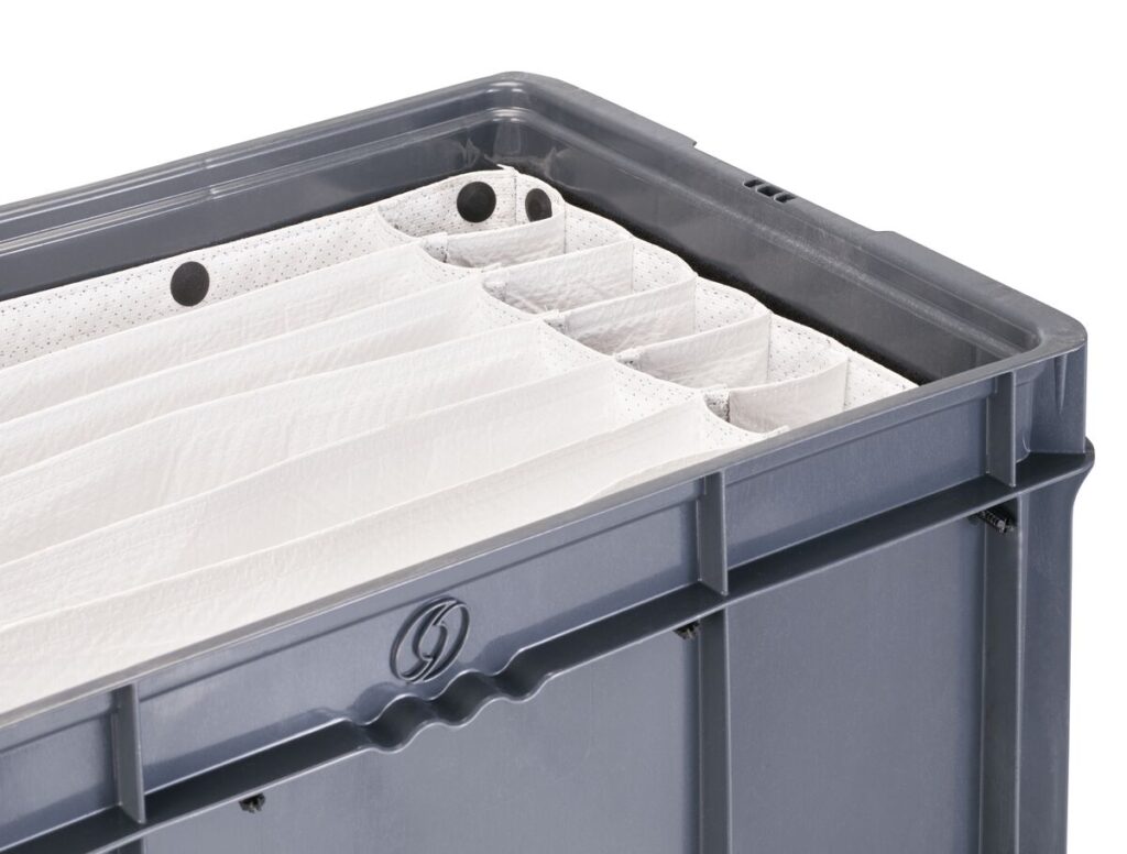 Plastic storage tote with a stack of white folded chairs and fabric dunnage placed inside.