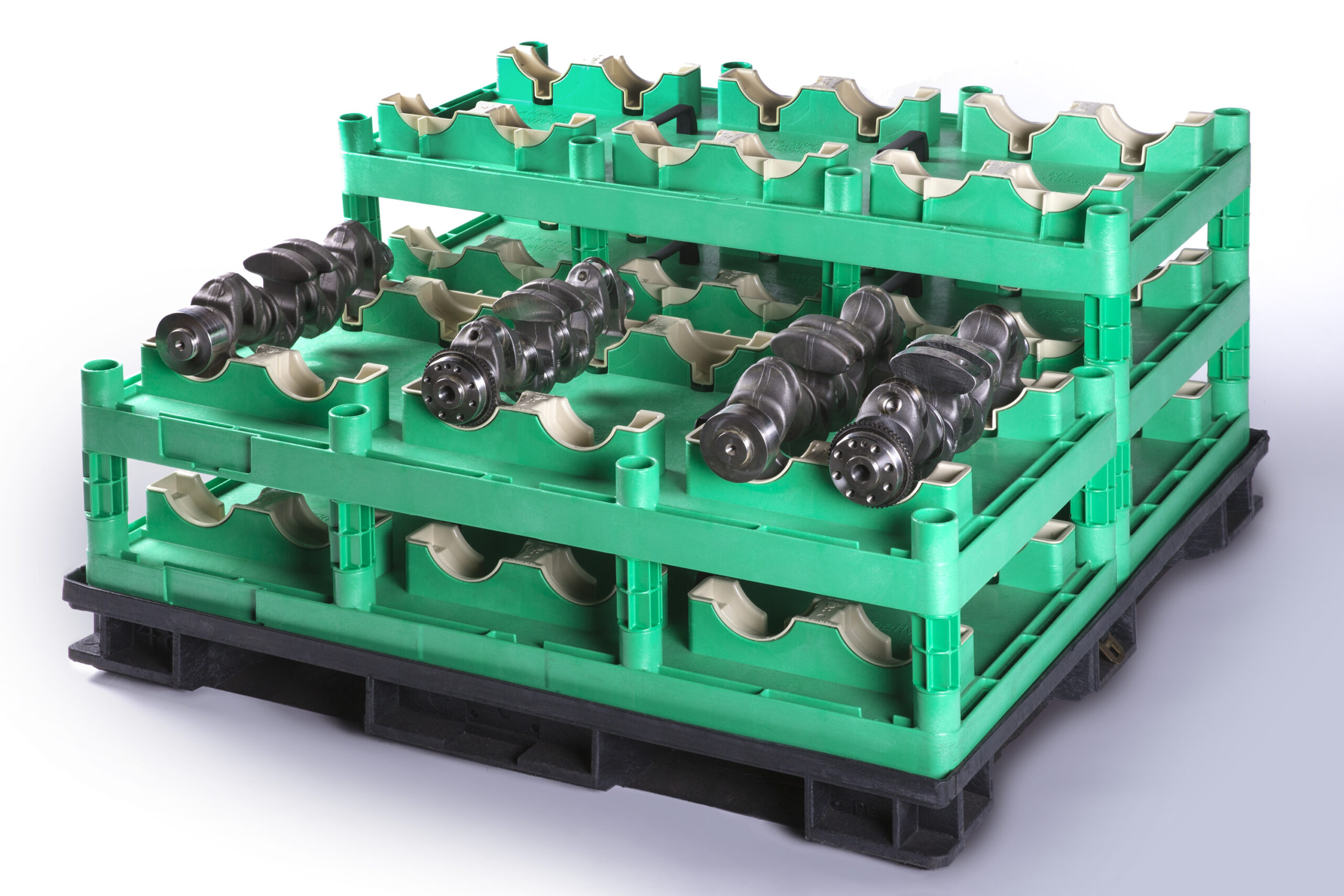 A green custom injection molded tray holds cylindrical black metal components neatly arranged in multiple tiers.